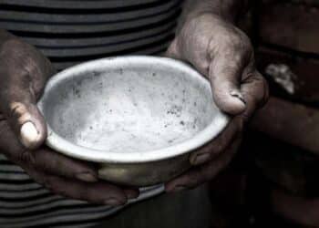 the poor old man's hands hold an empty bowl. the concept of hung